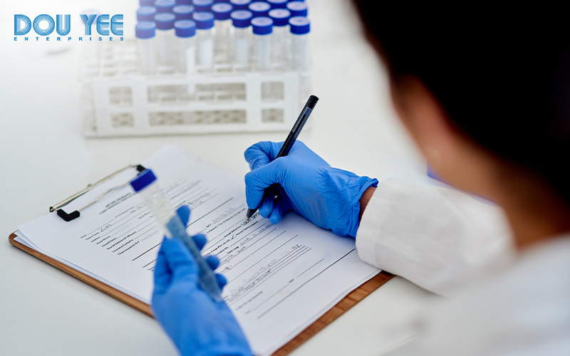 Laboratory worker writing on a form, managing data manually.