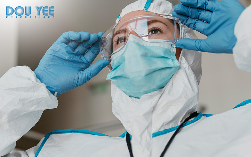 Woman putting on goggles as part of PPE protocol.